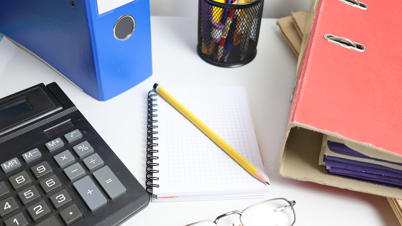 Bureau avec classeurs, calculatrice et carnet